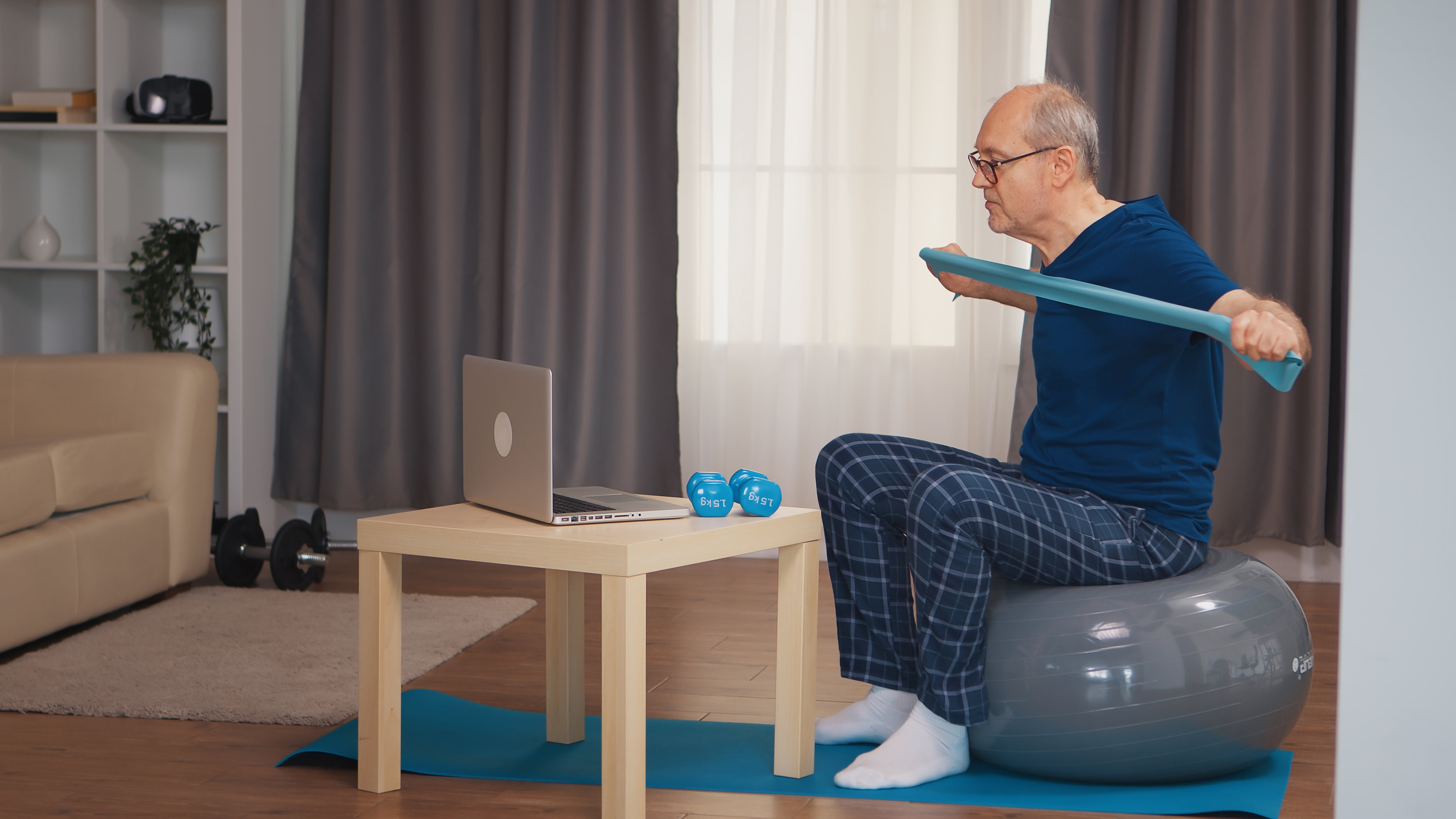 man doing PT exercises and meeting with physical therapist via a teletherapy visit