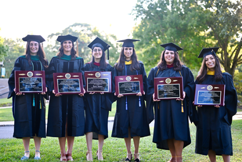 Six Touro students holding awards, standing together
