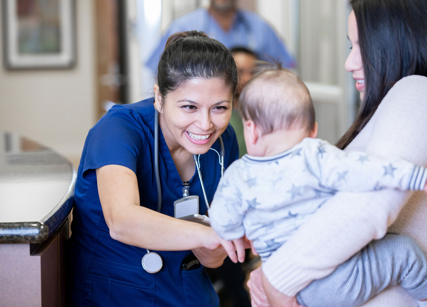 FNP smiling while interacting with baby at doctors office
