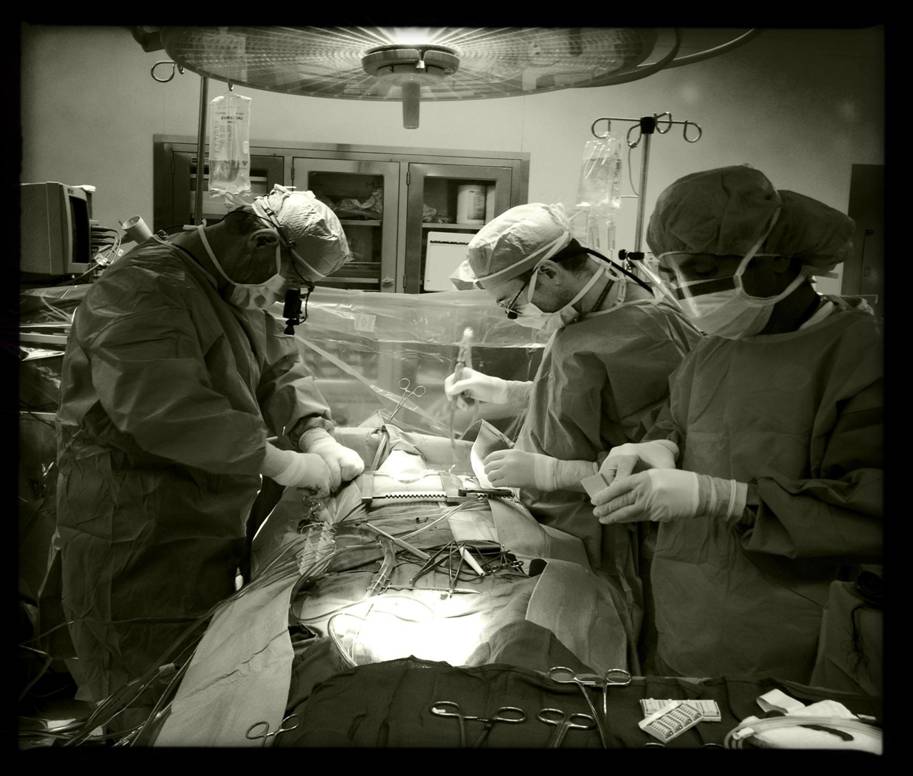 PA Thomas Burns, right background, assists in an open-heart surgery. 