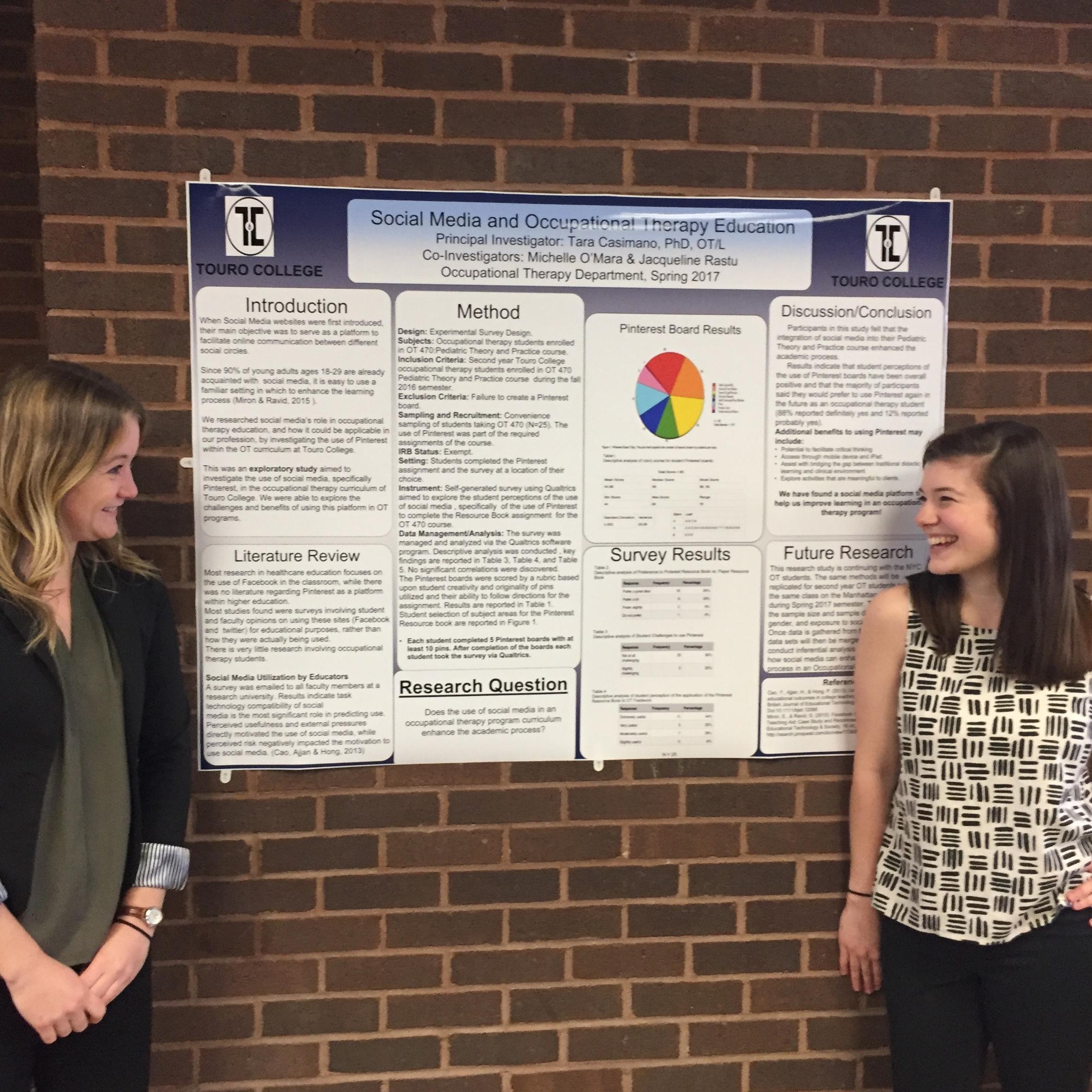 OT students Michelle O'Mara and Jacqueline Rastu share a smile by their completed poster about the use of social media as a tool for occupational therapy education. 