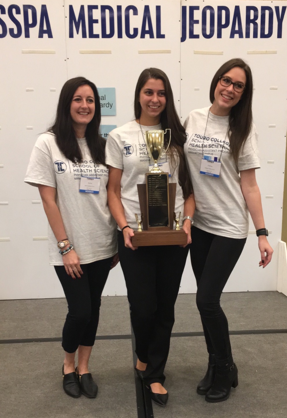 Students Sylvia Grabicki, Laryssa Llanio, and Chelsea Gifford holding their trophy from the Medical Challenge Bowl.
