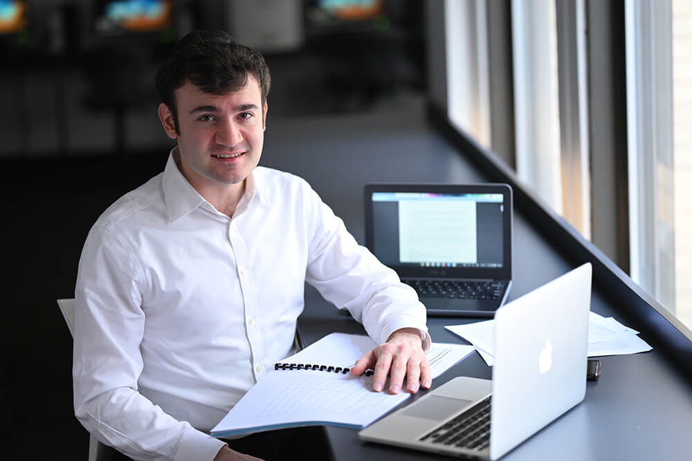 Dr. Yosef Sokol, sitting in front of 2 laptops and an open book