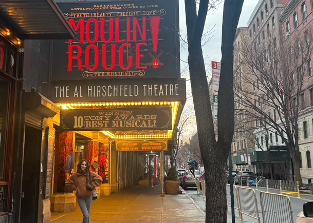 SHS DPT alum Kira Jarrar by the Broadway marquee of Moulin Rouge