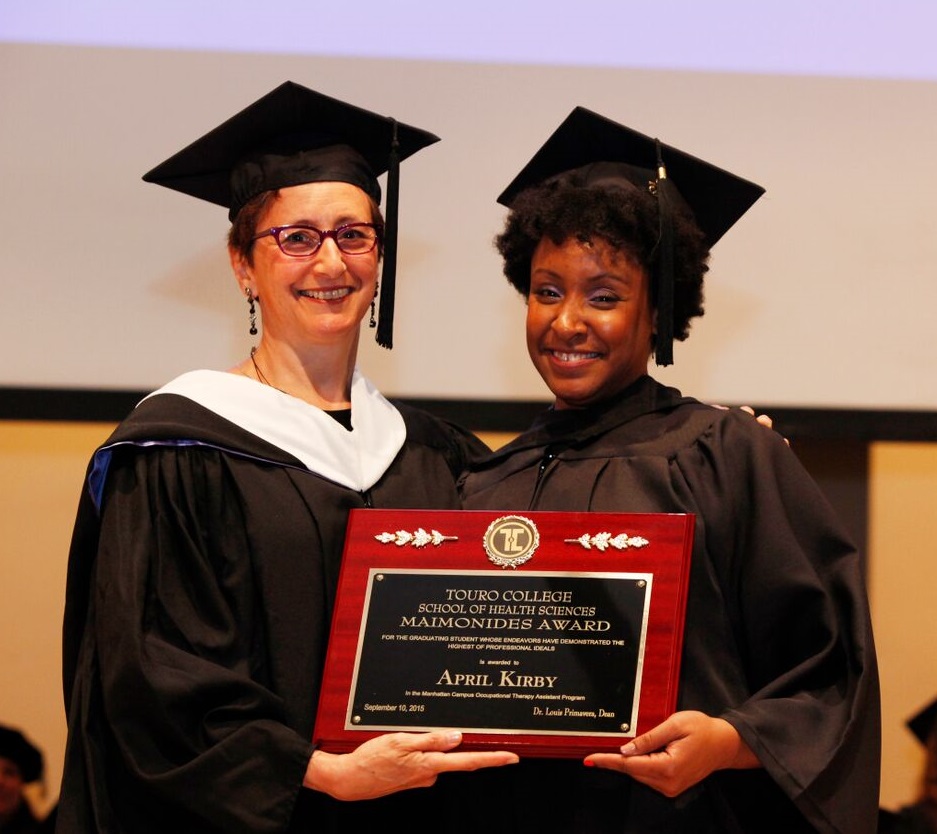 OT Assistant Program Supervisor Julie Kardachi presents Maimonides Award to April Kirby at School of Health Sciences commencement ceremony. \n