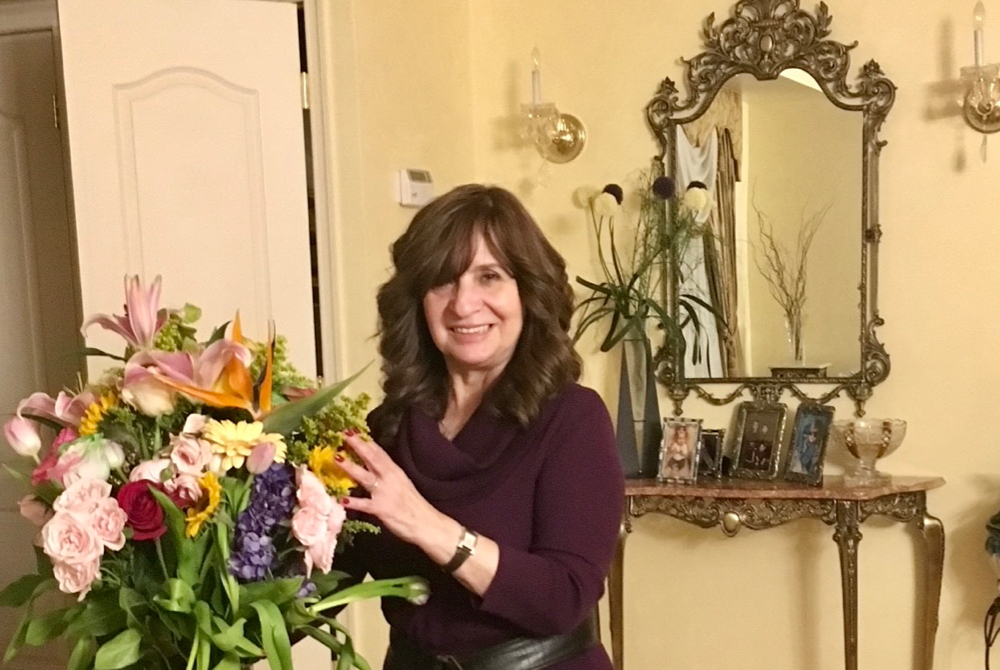 Rose Lefkowitz posing with flowers that were a gift from a student